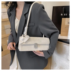 Detailed view of cream crossbody bag with elegant silk scarf and crystal buckle decoration