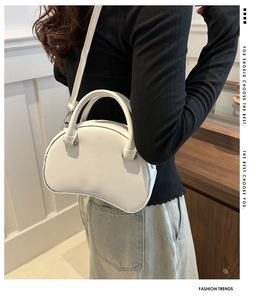 Detailed side view of white crescent bag on model showing size and strap length