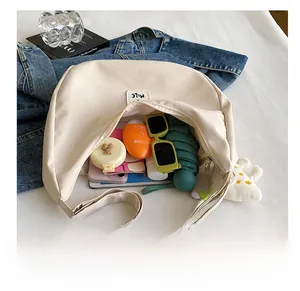 Intérieur spacieux du sac croissant beige contenant les essentiels du quotidien