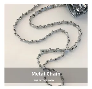 Close-up of a silver hardware chain with leather strap on a sequined fashion handbag