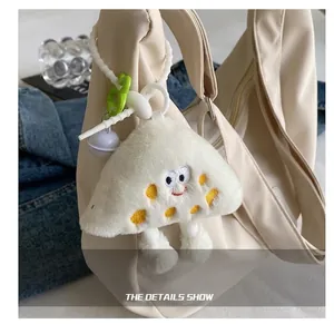 Gros plan d'une breloque en peluche avec broderie sur un sac en nylon blanc