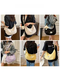 Détail du sac bandoulière en toile en quatre couleurs avec un pendentif champignon mignon