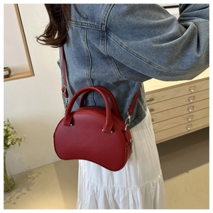 Minimalist red semi-circle crossbody bag for women with leather texture and silver hardware