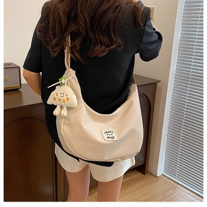 Sac à bandoulière croissant en nylon beige avec peluche et écusson décoratif chic