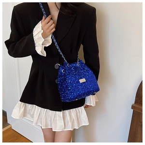 Detail of blue sequined bucket bag with silver chain strap and polished metal plate