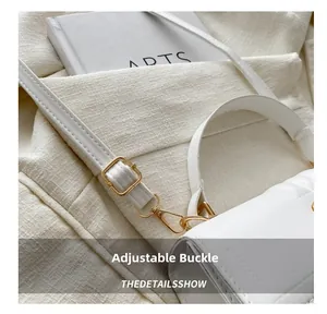 Gros plan de la bandoulière réglable en cuir blanc avec boucles dorées de qualité