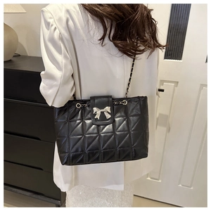 Black quilted tote bag with silver bow clasp and chain strap for daily commute