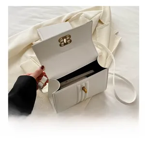 Sac bandoulière en cuir blanc avec boucle dorée montrant l'espace intérieur pour téléphone