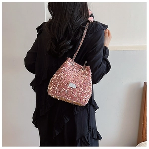 Detailed back view of a woman wearing a pink sequin bucket bag with a chain strap