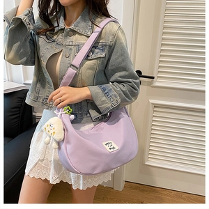 Détail du sac demi-lune en nylon lavande avec patch et breloque nuage pelucheux