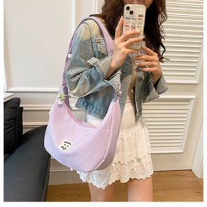 Selfie miroir montrant le sac bandoulière croissant en nylon lilas avec sangle réglable