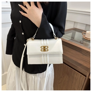 Détail du sac en cuir blanc avec lignes embossées et boucle dorée en forme de double B