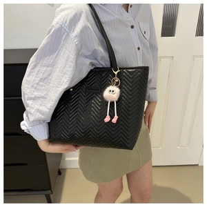 Grande borsa tote nera trapuntata a chevron con ciondolo a mostro di pelliccia rosa