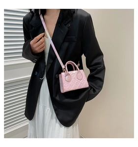 Dettaglio mini borsa trapuntata rosa con finitura lucida e tracolla rimovibile