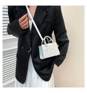 Close-up of holographic white mini square bag with diamond quilted texture on model