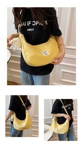 Détail du sac croissant en nylon jaune avec bandoulière réglable et breloque pelucheuse