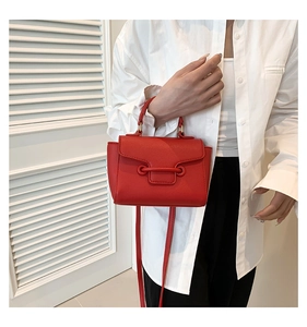 Fashionable red leather crossbody bag featuring a unique perforated ring buckle design