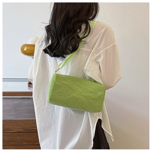 Minimalist bright green cylindrical crossbody bag with pleated nylon fabric texture detail