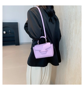 Close-up of lavender leather handbag with lychee texture and cylindrical buckle
