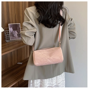 Detailed close-up of pink cylinder crossbody bag featuring unique pleated paper texture
