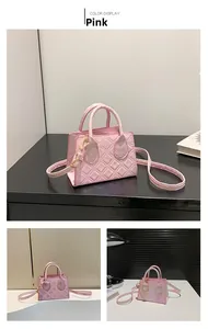 Detailed view of pink quilted mini square bag with golden hardware and round handles