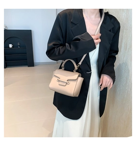 Fashionable beige mini bag worn with black blazer and white dress for a chic summer look