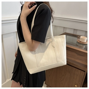 Dettaglio della borsa tote bianco crema con trama a onde verticali e tracolla sottile