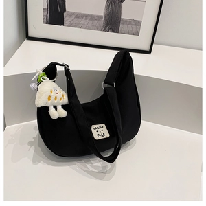 Sac bandoulière demi-lune en nylon noir avec écusson sourire et porte-clé peluche