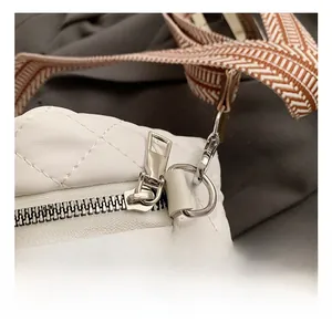 Nahaufnahme der eleganten weißen Stepptasche mit silbernem Metallreißverschluss und D-Ring