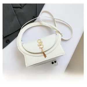 Detailed top view of white crossbody bag with round handle, gold logo and fringe detail