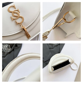 Detail of white semi-circular handbag with gold logo, metal tassels and precise stitching