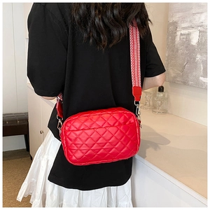 Detail einer roten Stepptasche mit stylischem, breit gestreiftem Web-Schultergurt