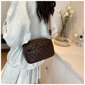 Detail der dunkelbraunen Stepptasche mit stylischem geometrischem breitem Schultergurt