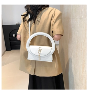 Close-up of a white leather handbag featuring a large circular handle and gold S logo
