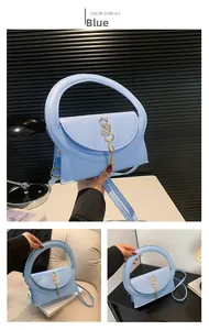 Détail du sac à main bleu clair avec breloque lettre dorée et pompon métallique