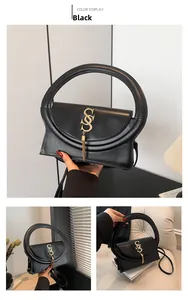 Détail du sac bandoulière noir avec grande poignée ronde, logo S doré et long pompon