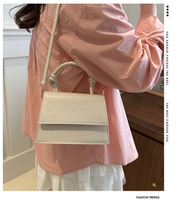 Detail view of white crocodile pattern tote bag with knot handle and adjustable strap