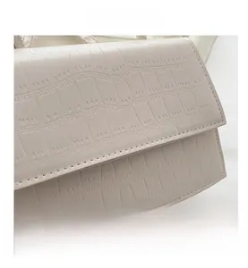 Macro shot of minimalist cream crocodile embossed leather with detailed stitching