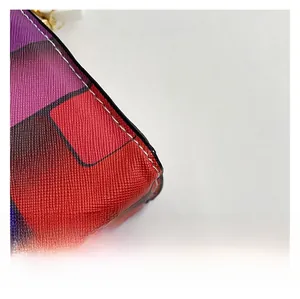 Macro view of multi-color geometric leather panels with white stitching and gold zipper