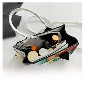 Top view of the checkered handbag interior showing a phone, lipstick and ample storage