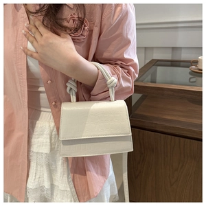 White croc-effect crossbody bag styled with elegant floral shirt and lace skirt