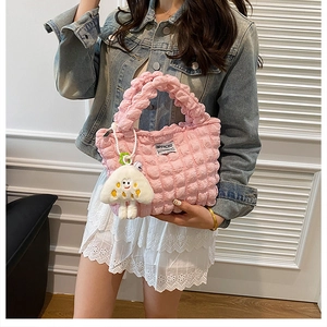 Detalle de bolso acolchado rosa con textura de burbujas y colgante de peluche