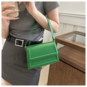 Dettaglio della borsa verde brillante con cuciture rettangolari e texture in pelle liscia