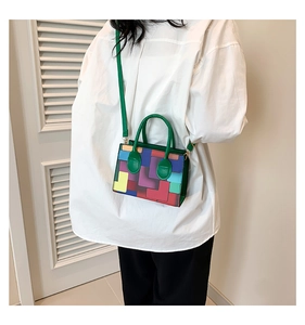 Fashionable color-block crossbody bag styled on model against a white shutter backdrop