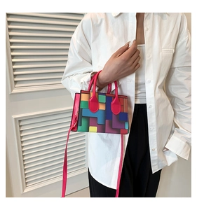 Detailed view of color-block tote bag with pixel patterns and pink shoulder strap