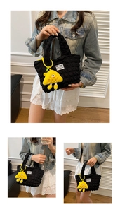 Detalle del bolso nube de nailon negro con un tierno colgante de monstruo amarillo