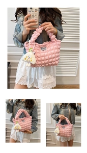 Detalle de bolso rosa fruncido con textura acolchada y colgante de seta de peluche