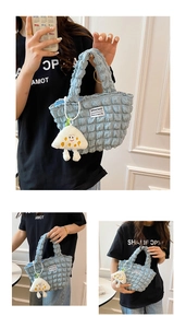 Detalle del bolso azul claro con textura de burbujas y un colgante de nube de felpa