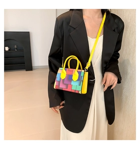 Fashionable colorful patchwork crossbody bag shown on model with yellow handles
