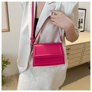 Borsa a tracolla quadrata color magenta abbinata a un elegante completo bianco